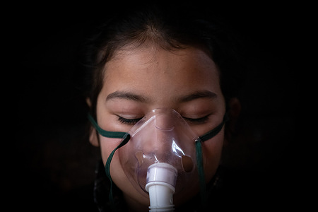 A Kashmiri girl breathes with the help of a nebuliser while receiving inhalation therapy at her home during a power outage in the outskirts of Srinagar. Electricity production in Kashmir has decreased during the winter, leading to unscheduled power outages across the region. These disruptions in electricity have significantly impacted the daily lives of the people in Kashmir.