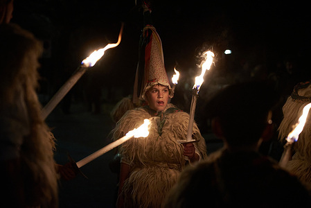 A young joaldunak carries a torch during the traditional parade of the Olentzero and Mari Domingi. Olentzero is a special Christmas character from Northern Spain. Dressed in blue pants and a checkered shirt with a charcoal-stained face, he brings gifts and candies to children to announce that Christmas is coming.Olentzero is a popular figure in Basque culture. Every December 24th, Olentzero and his wife Mari Domingi roam the streets, sharing presents and sweets with kids, spreading joy, and signaling the arrival of Christmas. The are accompanied by Joaldunak who are said to protect cattle, drive away bad spirits, and ensure a good harvest.