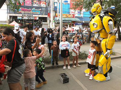A young boy wearing basketball jersey poses for a picture together with American transformer movie character Bumblebee on Christmas Day. A meet and greet with photo op activity was held at Paskuhan Village in Malabon City.