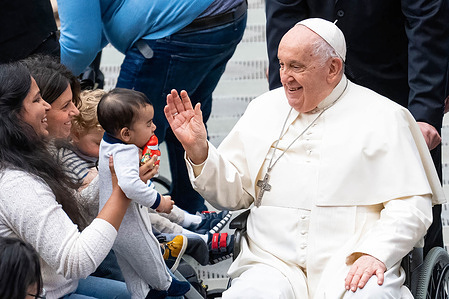 Pope Francis greets and blesses a child after the traditional Wednesday General Audience in Paul VI Audience Hall in Vatican City.