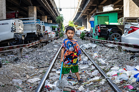 A young boy plays amidst garbage on the railway tracks in Bangkok's Khlongtoey slum district. Plastic waste is a huge issue in Thailand and there is still little awareness of issues around recycling and sustainability, particularly in poorer areas of the city.