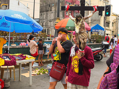 A Black Nazarene devotee seen carrying a replica of the crucified Christ. Catholic Believers flocked to Quiapo Church in Manila for the Feast of Black Nazarene. Some believers stood on the streets of Quiapo to wipe the Nazarene replicas with their towel and handkerchiefs while waiting for the arrival of the annual procession that re-enacts the transferal of the Black Nazarene from its original shrine in Intramuros to the Minor Basilica of the Quiapo Church.