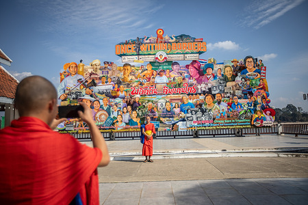 Burmese monks take pictures in front of a large painting depicting the 3 borders countries, Myanmar, Thailand and Loas tourism spots call "Once Within Border" at the Golden Triangle in Chiang Saen.