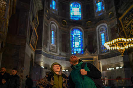 Tourists look up at the decorations on the ceiling of Hagia Sophia. The Hagia Sophia, was converted from a museum to a mosque in 2020 by the decision of President Erdogan, visitors who are tourists will be charged a fee of 25 euros as of January 15, 2024, by the decision of the Ministry of Culture and Tourism.