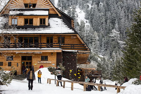 Tourists are seen in front of the Horsky Hotel Popradske Pleso at the High Tatras. High Tatra Mountains are a mountain range along the border of northern Slovakia in the Presov Region, and southern Poland in the Lesser Poland Voivodeship. The highest peak of the High Tatras is Gerlachovsky stit (Gerlachov Peak), at 2,655 meters.