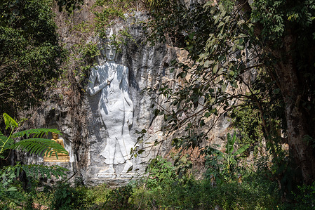 A view of a Buddha carved into the mountain at the Tham Tu Pu Temple. Samnaksong Tu Pu, also known as Tu Pu Cave Temple, is a residence for forest monks situated in a limestone mountain 5 km from Chiang Rai.