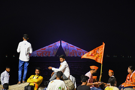 People visit to watch Bandra Worli Sealink lit up in light projecting an image of the Hindu deity Lord Ram in Mumbai. Bandra Worli Sealink was lit up with the light-projecting image of Hindu deity Lord Ram to commemorate the consecration of Ram temple in Ayodhya in the state of Uttar Pradesh.