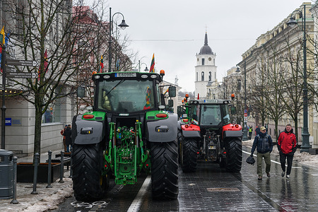 People seen walking past hundreds of tractors stand on central Gediminas avenue during the farmers' protest. Farmers' protest continues for the third day in Vilnius. Thousands of farmers came to the capital of Lithuania with 1,300 tractors and other agricultural machinery, some of which were parked on the central Gediminas avenue. Farmers demand to cancel obligations to restore perennial meadows, a return to the old order of using branded diesel fuel, cancel this year's increase in the excise tax on liquefied petroleum gas, to solve the so-called milk crisis, refuse to expand protected territories and stop the transit of Russian grain.