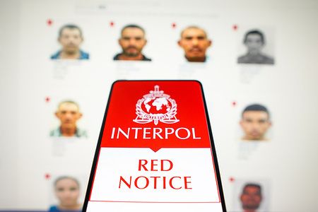 In this photo illustration, the Interpol Red Notice logo is displayed on a smartphone screen.