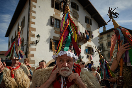 Vixente, 66 years old, Ioaldunak ties his hat, called Ttuntturro, in preparation for the carnival celebration in Ituren. The Ituren Carnival is an ancient festival in two Basque towns, Ituren and Zubieta. People ring cowbells to scare off the devil and bring luck to farmers. It's one of Europe's oldest carnivals, dating back before the Roman Empire.