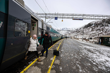 Passengers are seen getting off one of the carriages of a train at Myrdal station. The Bergen train route, known as Bergensbanen, is a rail experience that offers travelers a scenic journey through Norway's most breathtaking landscapes. The rail line provides a connection to the Nordic wilderness as the train crosses high plateaus, fjords, crosses rivers, and offers breathtaking panoramas. The trains offer on-board amenities, including restaurant cars where passengers can enjoy Norwegian food and drinks while watching the scenery pass by.