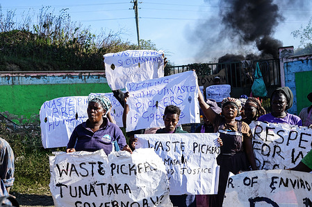 Waste pickers hold placards in front of a smoky bonfire during a protest to air their grievances at The Gioto Dumping Site. Waste pickers under their organization, Nakuru County Waste Pickers Association, working in Gioto Dumping site protested demanding government’s attention to address their grievances. The group is concerned about the impacts Kenya’s New Sustainable Waste Management Act and a Global Plastics Treaty on their jobs at the dumping site, fearing a drastic reduction in the waste they rely on. They are calling for a #JustTransition to be able to eke a living.