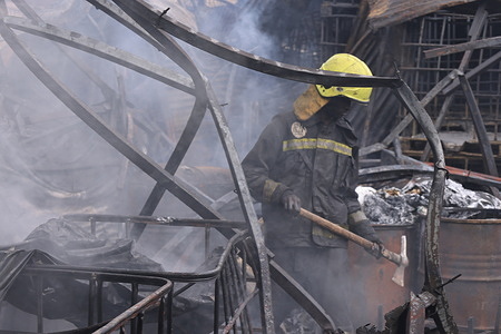 A firefighter from Nairobi City county seen trying to put out fire that razed down a small scale traders' market in downtown Nairobi. The traders were left counting huge losses due to the fire that burnt down their business premises.