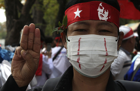 A protester makes a three-finger salute during a rally to mark the third anniversary of the coup in Myanmar. The demonstration was held in front of the United Nations Building in Bangkok. Myanmar's military seized power on February 1, 2021, ousting the civilian government and arresting its de facto leader, Aung San Suu Kyi.