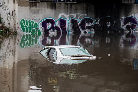 A vehicle is submerged in the rising flood waters in Long Beach.