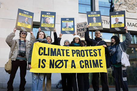 Climate change activists and supporters of Greta Thunberg hold a banner and placards during the demonstration outside Westminster Magistrates Court in London. The Swedish climate campaigner was one of five activists appearing at court on Thursday charged with failing to comply with an order to stop protesting outside an oil industry summit in central London last year.