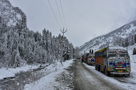 Drivers walk past their stranded trucks carrying essential supply on a closed Srinagar-Ladakah national highway during snowfall in Sonamarg, about 100kms from Srinagar, the summer capital of Jammu and Kashmir. After enduring a prolonged dry spell, the Himalayan regions of Kashmir have finally witnessed a much-anticipated snowfall, causing disruptions to normal life.
