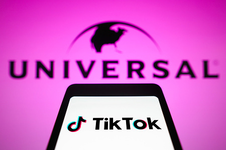 In this photo illustration, the TikTok logo is displayed on a smartphone screen with the logo Universal Music in the background. Universal Music announced that it will remove its songs from TikTok, as it will not renew content licensing.