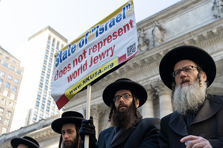 A member of the Hasidic Jewish group "Neturei Karta" holds a placard saying "State of Israel does not represent Jewry" at a rally for Palestine and against the NYPD's enforcement of laws preventing demonstrators from using electronic sound systems without a permit.