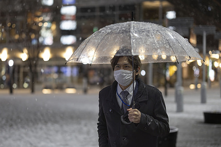 A pedestrian with an umbrella walks towards a subway station during a rare snow day in Yokohama. The greater Tokyo area also known as Kantō-area received a significant portion of snowfall on February 5, 2024. Local government authorities and private companies have issued warnings to citizens and employees regarding the snow and commuting to work.