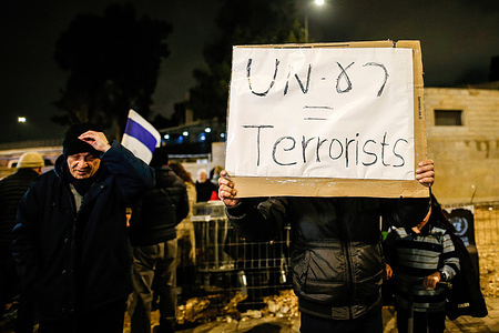 A protester holds a placard in front of the UNRWA office in Jerusalem during a demonstration calling for the expulsion of the UNRWA office from the city. Israel recently claimed that 13 of 13,000 Gaza employees of the UN Relief and Works Agency (UNRWA) participated in the October 7 attacks against Israel, and the UN agency fired several employees in the wake of the allegations, which have not been made public.