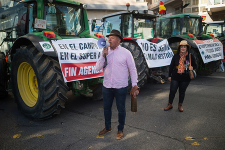 A protester is seen speaking with a megaphone as tractors block the entrance of Port of Malaga during a farmer's protest against unfair competition and for better working conditions. Dozens of farmers are demonstrating in the centre of cities across Spain to denounce price rises, improvements in their working conditions and against European agricultural policy. Farm workers have blocked the main entrances to city centres and strategic points.