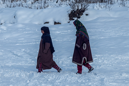 Kashmiri nomadic women walk along a snow-covered field on a cold winter day after heavy snowfall in Doodhpathri, about 45km north-east of Srinagar. The weather in the Kashmir valley has improved after receiving fresh snowfall following a period of drought. However, strong cold wave conditions continue in Kashmir, with minimum temperatures remaining several degrees below freezing in most areas of the region, according to weather officials.
