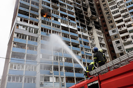 Firefighters putting out a fire in a building damaged by falling debris of a shot-down Russian missile following a missile strike in Kyiv. At least four people were killed and 19 others were injured after Russian shelling hit Kyiv, according to Ukrainian Emergency Services.