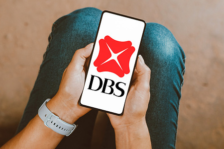 In this photo illustration, the DBS Group Holdings logo is displayed on a smartphone screen.