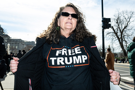 Woman wearing a t-shirt saying "Free Trump" in front of the Supreme Court.