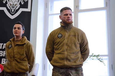 Serhiy Filimonov (call sign Filya) (R), and Alina Mykhaylova (L) are officers of the Armed Forces of Ukraine signed to the "Da Vinci Wolves" battalion are seen during the opening of the recruiting center for the recruitment of volunteers. Fighters of the "Da Vinci Wolves" battalion announced the opening of a recruiting center for the recruitment of fighters to resist Russia's military aggression in Kyiv.