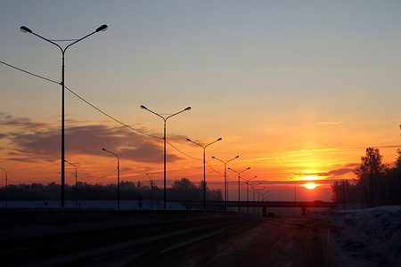 Sunrise in winter over the road, Priozerskoe highway in the Leningrad region.