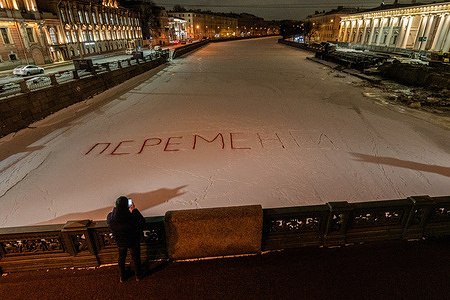 A man takes a photograph of the huge inscription '(We demand) Change' on the ice covering the Fontanka River in St. Petersburg. In St. Petersburg, on the ice of the Fontanka, an unknown person left a large inscription “Change” with an image of a “tick” in a square. The message appeared under the Anichkov Bridge and reminded of the upcoming presidential elections in Russia.