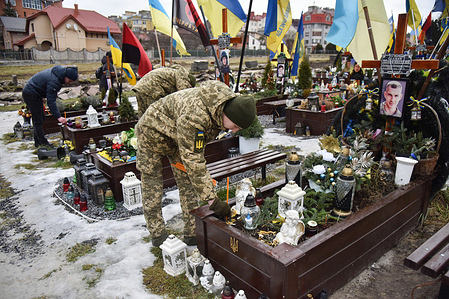A military cadet places a candle on the grave of a Ukrainian soldier who died in the Russian-Ukrainian war and was buried at the Lychakiv cemetery in Lviv. Ukrainian soldiers who lost their lives since the onset of the Ukrainian-Russian war in Feb 2022 are laid to rest in Lviv at the Lytsakiv cemetery. The government has intentions to construct a military memorial complex at this location, dedicated to honoring their sacrifice and commemorating their bravery.
