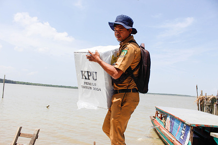 An official from the Jaring Halus village office seen carrying the election ballot box to be taken to the village office. In preparation for the upcoming election on February 14, 2024, the General Elections Officer is distributing ballot boxes to all community voting precincts across the country. They anticipate that 200 million voters will cast their votes nationwide.