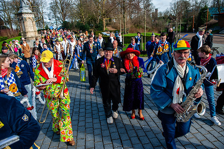 The couple seen surrounded by a music band. The farmer's wedding is one of the Dutch Carnival traditions, especially in Limburg, North Brabant, and Gelderland. The couple arrived at the Valkhof chapel, wearing traditional farmer's clothes and surrounded by people wearing vibrant costumes to perform a fake wedding.