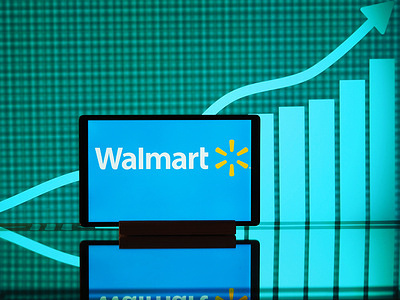 In this photo illustration, the Walmart logo seen displayed on a smartphone screen with a graph in the background.