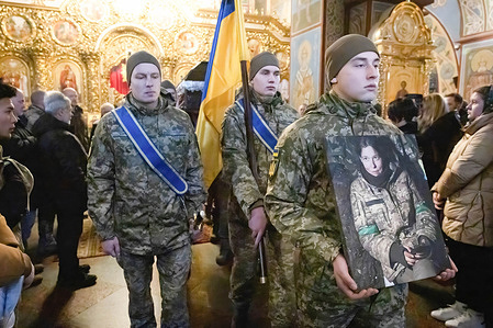 A Ukrainian serviceman carries a portrait of Diana Savita Wagner, a German combat medic during her funeral ceremony in Kyiv. Diana Savita Wagner, who joined Ukrainian Armed Forces as a volunteer was killed by Russian troops in the east of Ukraine.