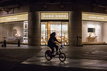 A cyclist rides past the Zara Home store in Antwerp, Belgium. Zara Home is a company that belongs to the Spanish Inditex group dedicated to the manufacturing of home textiles.