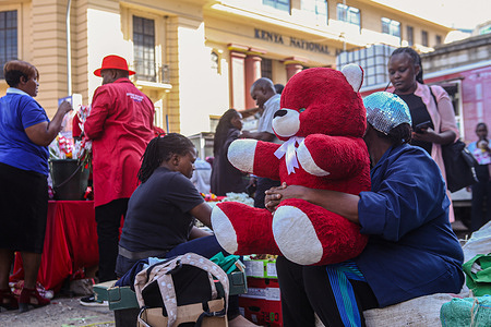 A Kenyan vendor waits on customers as she holds a teddy bear for sale along Tom Mboya street during Valentine's Day in Nairobi. Kenyans filled various streets across the country as they celebrated Valentine’s Day despite the harsh economic situation currently being experienced. Florists and gift shops spread across Nairobi city also recorded increased traffic as Kenyans seized the moment to buy gifts as well as hampers for their loved ones. Kenya is a large exporter of flowers to Europe and the Middle East.