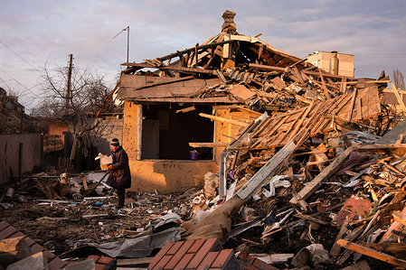 A man removes belongings from a house damaged by a Russian missile attack in Chuguev, a city in Kharkiv Oblast. In the early hours of, February 15, a Russian missile struck a residential area of Chuguev in Kharkiv, claiming the life of a 67-year-old woman.