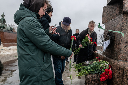 People gather at a monument to victims of political repression to honor the memory of Russian opposition leader Alexei Navalny a day after news of his death, in St. Petersburg.