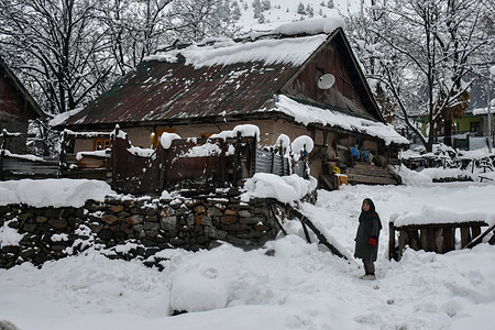 A girl looks on as she stands outside her house after heavy snowfall in Gagangir, about 90 km from Srinagar. Heavy snowfall and rains in Kashmir have left the valley cut off from the rest of the world. All highways are closed to traffic. The weatherman has forecast that rain/snow will continue for another 48 hours, which could also result in light snowfall in the plains of the Valley.