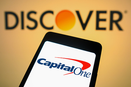 In this photo illustration, the Capital One Financial logo is displayed on a smartphone screen with the logo Discover Financial Services in the background.
Capital One Financial Corporation (NYSE: COF) and Discover Financial Services (NYSE: DFS) have jointly declared a definitive agreement, wherein Capital One will acquire Discover in an all-stock deal valued at $35.3 billion.