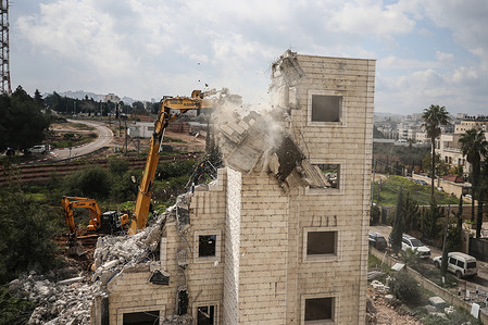 Israeli military excavator demolishs the house of the Palestinian "Abu Zahriah" family, which was reportedly built without a construction permit, in the Beit Hanina neighborhood of Israeli-annexed east Jerusalem. Israeli forces destroyed a building belonging to Palestinians in the Beit Hanina district of East Jerusalem. During the demolition of the building, which was stated to belong to the Palestinian "Abu Zahriah" family, Israeli forces took security measures in the area and did not allow the surrounding Palestinians to approach during the demolition.