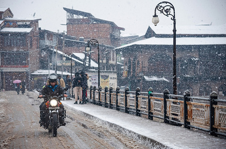 A man on a motorbike rides along a snow-covered road amidst heavy snowfall in the old city of Srinagar. Fresh snowfall in the Kashmir valley has severely disrupted daily life. Flight operations, surface transport, and regular activities have all been brought to a standstill. Additionally, electricity supply has been disrupted in many areas. The Jammu and Kashmir administration has issued a high-danger level avalanche alert for several regions over the next 24 hours, urging residents to exercise caution.