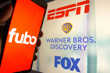 In this photo illustration, the FuboTV Inc. logo is displayed on a smartphone screen and ESPN, Warner Bros. Discovery and FOX logos in the background. FuboTV, a streaming service primarily focused on live sports, has filed an antitrust lawsuit against ESPN, Fox, Warner Bros. Discovery, and Hulu. These companies are collaborating to launch a sports-streaming venture in the fall. The lawsuit has been initiated in the Southern District of New York, with FuboTV requesting a jury trial.