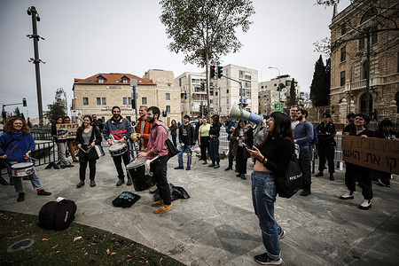 Israeli anti-war activists play drums and hold placards expressing their opinion at Paris Square near Israeli Prime Minister Benjamin Netanyahu's residence during the demonstration. Protesters assembled in West Jerusalem to denounce the ongoing conflict between Israel and Hamas, urging for an immediate cease-fire. They also demanded a hostage swap with Hamas.