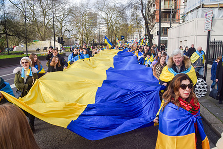 Protesters march with a giant Ukrainian flag during the demonstration in Park Lane. Thousands of people marched in Central London in solidarity with Ukraine on the second anniversary of the attack by Russia.