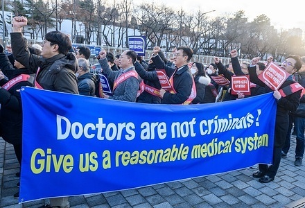 South Korean doctors hold a banner expressing their opinions near the Presidential Office during the protest. South Korea has raised its public health alert to the highest level, authorities announced on February 23, saying health services were in crisis after thousands of doctors resigned over proposed medical reforms.